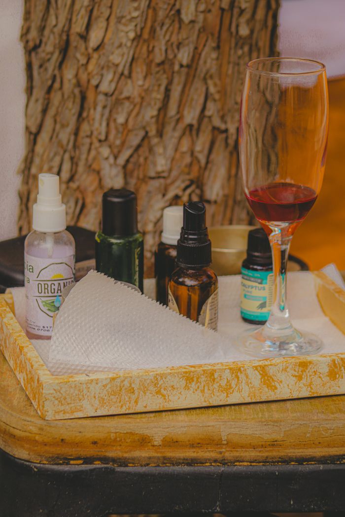 social-feed-img-04 A luxurious spa scene featuring essential oils and a glass of red wine, perfect for relaxation.