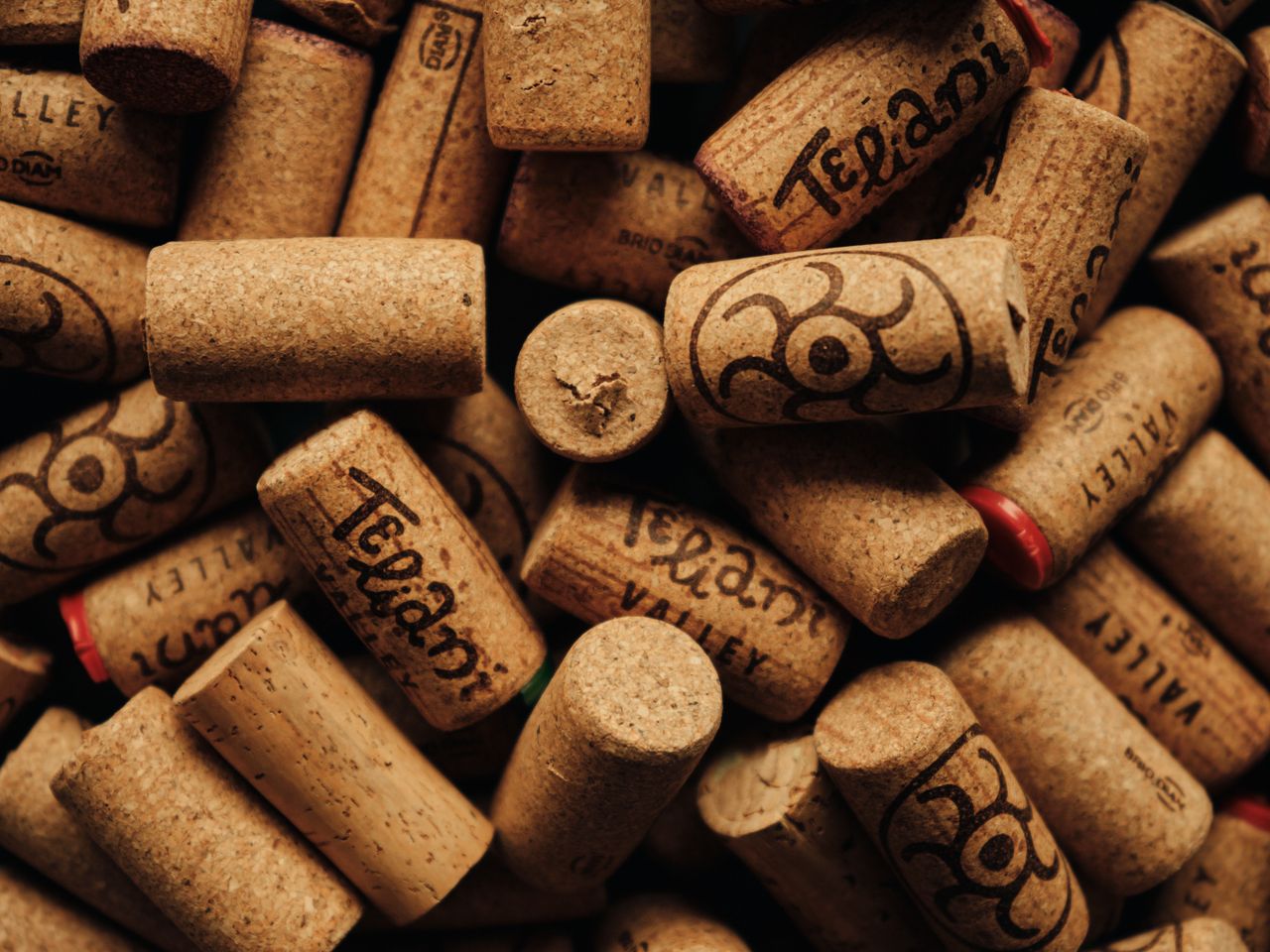 Close-up shot of wine corks with distinct markings showcasing winery names and designs.