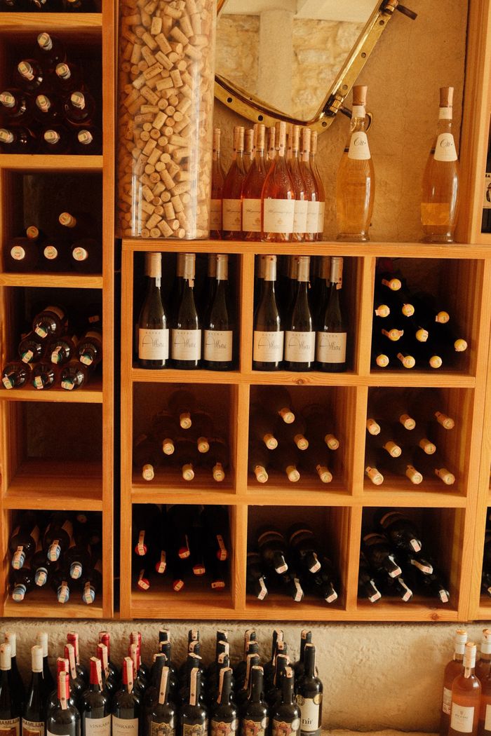 social-feed-img-01 Assorted wine bottles in a wooden rack, showcasing wine cellar elegance and organization.